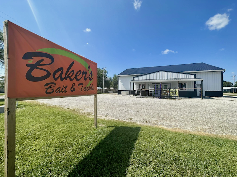 A "Baker's Bait & Tackle" sign outside of a storefront on a sunny day.
